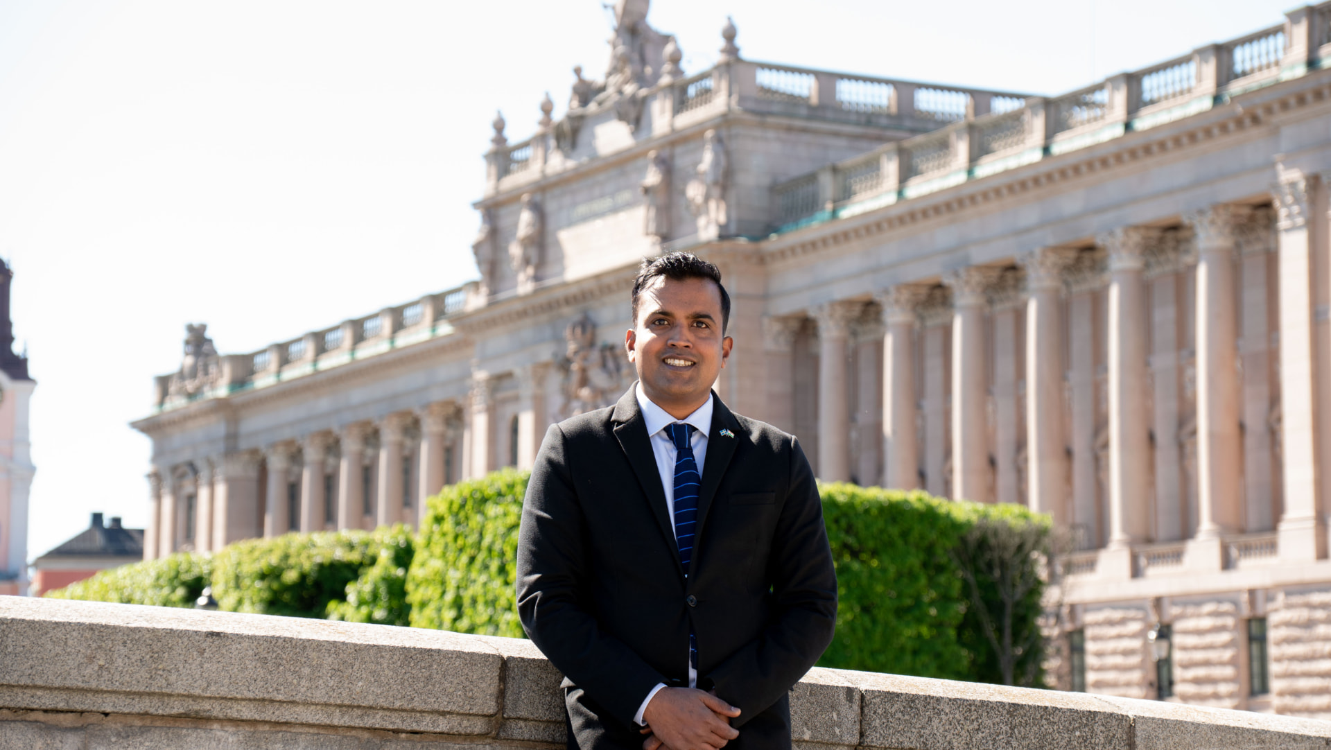 Vivek Noel Munigala framför Riksdagshuset i Stockholm